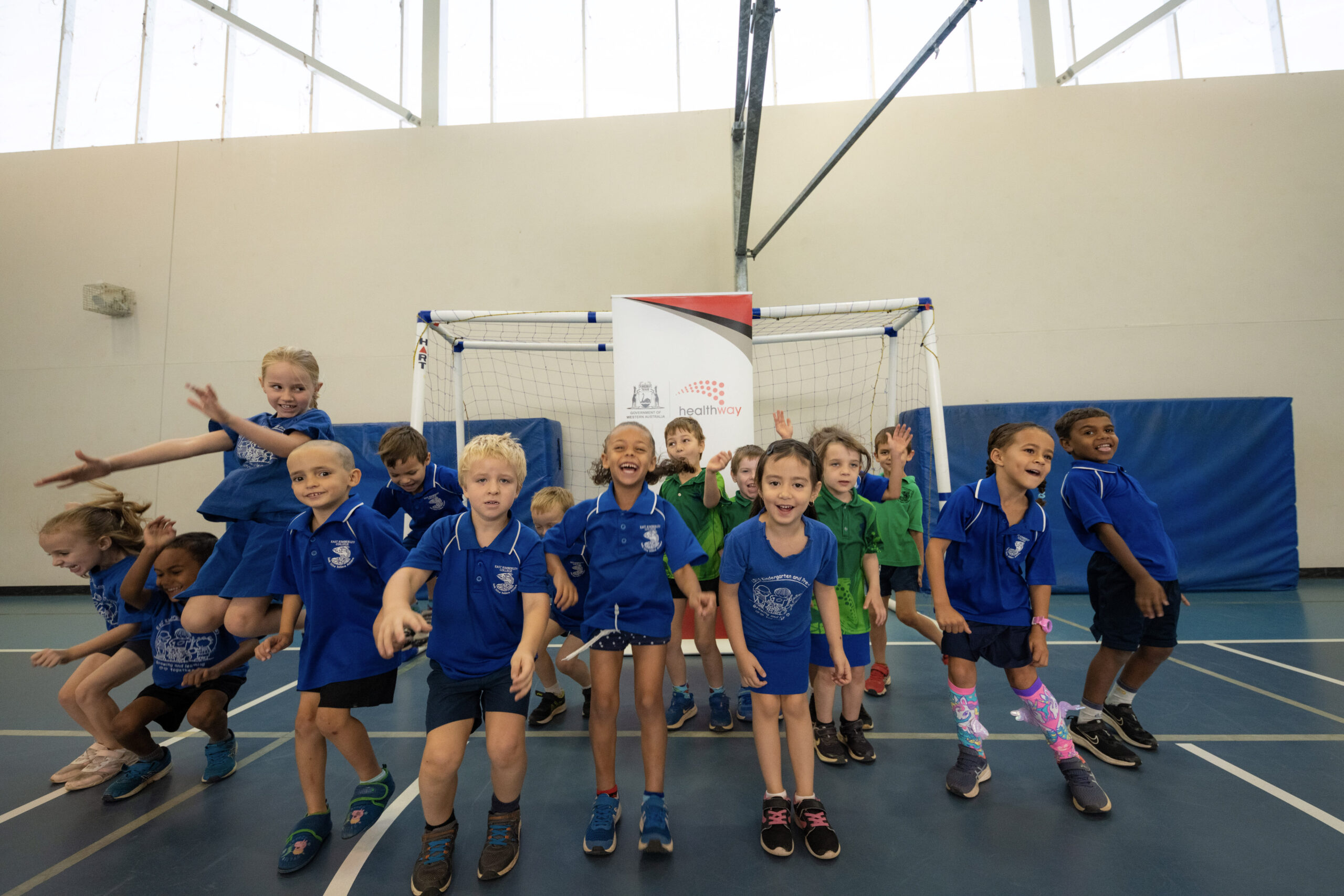Primary school students practicing jumping and coordination during a structured physical literacy activity supported by the KIDDO program. 