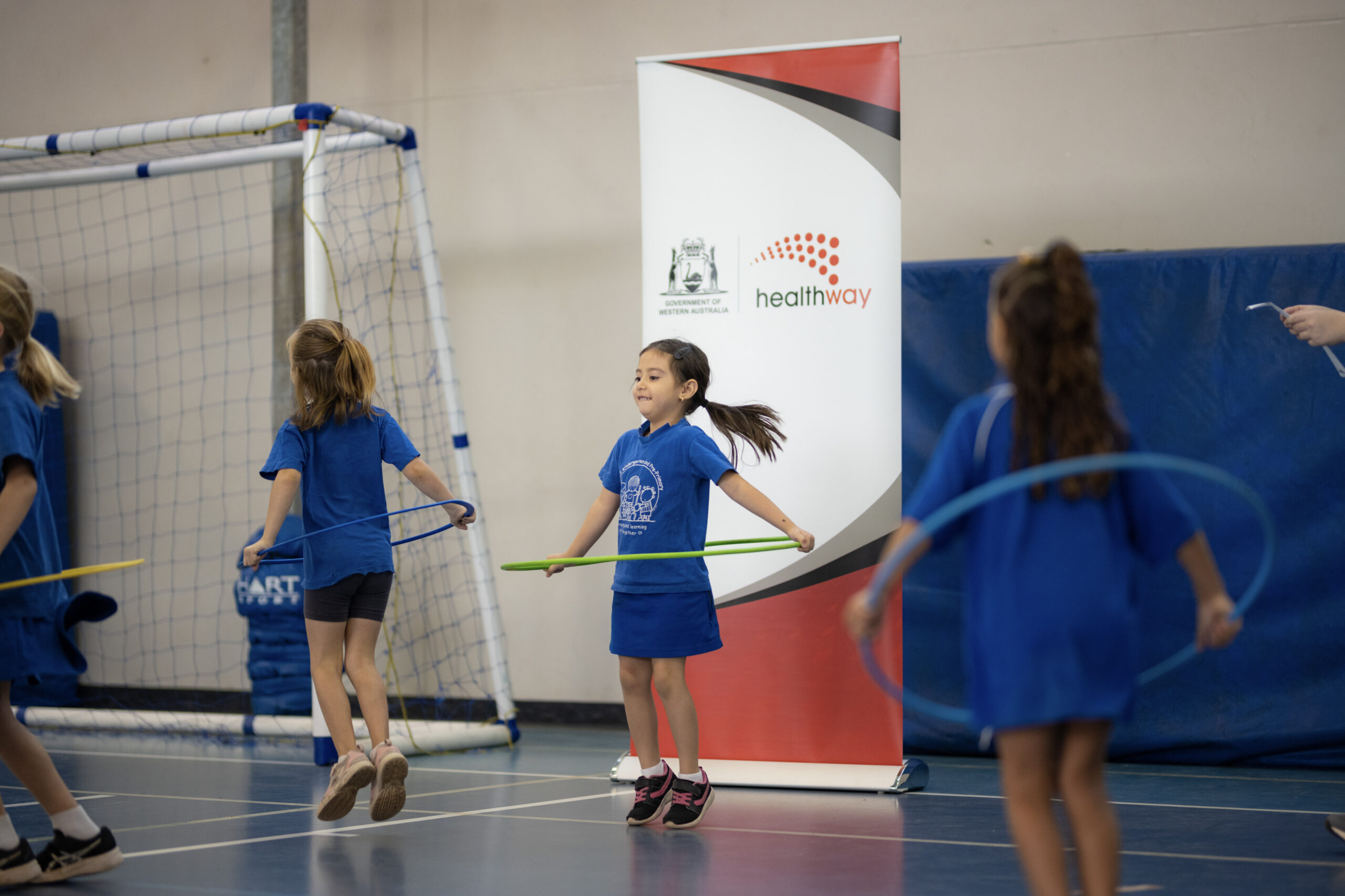 Children engaging in movement-based learning activities indoors, developing fundamental movement skills through the KIDDO program. 